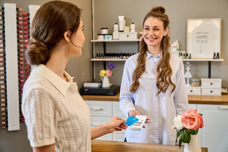 Klant betaalt met haar pas op een myPOS Go 2 aan de balie van een nagelsalon