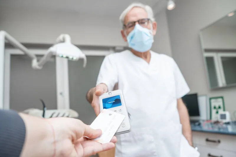 Patiënt betaalt met een bankpas op een myPOS Go 2 in de behandelkamer van een tandarts